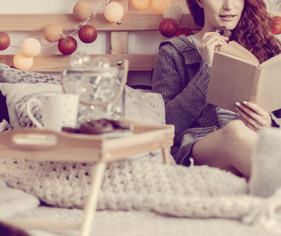 Lesende Frau auf dem Bett